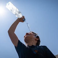 Ein Kind übergießt sich mit Wasser aus einer Flasche