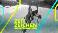 Eine Überlebende des JAL-Flugs 123 wird von einem Retter gehalten, während die beiden in einen Helikopter gehieft werden (13.08.1985)