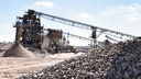 Kiesgewinnungsanlage mit Kieshaufen im Vordergrund