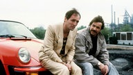 Götz George als Horst Schimanski (rechts) neben Günther Maria Halmer in einer Szene im Tatort "Grenzgänger" (1981)