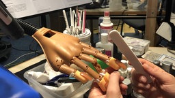 Produktionsbild des Hörspiels "Nagelneu": Eine Holzhand wird während der Aufnahme manikürt.