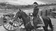US-General William Sherman auf einem Pferd, neben ihm steht eine Kanone