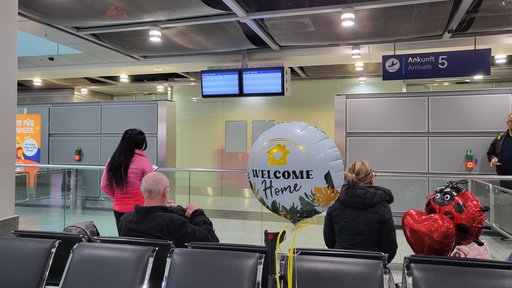 In der Ankunftshalle des Düsseldorfer Flughafens warten Angehörige der Menschen, die mit der ersten Maschine seit dem Wochenende aus Dubai kommen.