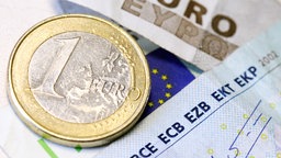 Ein-Euromünze und Teile von Euroscheinen