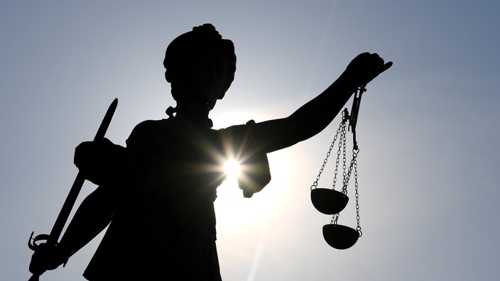 Eine Justitia-Statue im Gegenlicht 