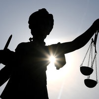 Eine Justitia-Statue im Gegenlicht 