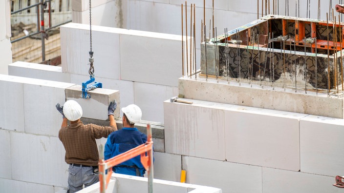 Bauarbeiter setzen eine Mauer auf einer Baustelle