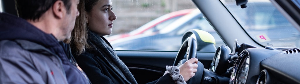 Eine junge Frau sitzt mit ihrem Vater im Auto