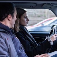 Eine junge Frau sitzt mit ihrem Vater im Auto