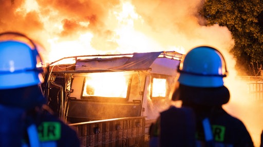 Einsatzkräfte löschen ein Feuer auf einem Campingplatz.