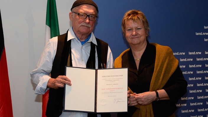 Träger des Bundesverdienstkreuzes Hans W. Geißendörfer und stellvertretende Ministerpräsidentin des Landes Nordrhein-Westfalen Sylvia Löhrmann