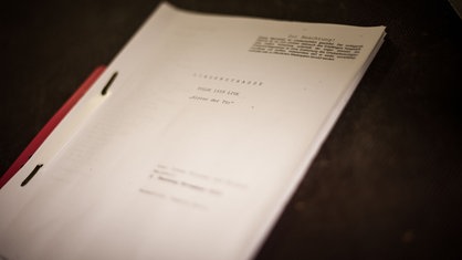 Ein Drehbuch vor dunklem Hintergrund.