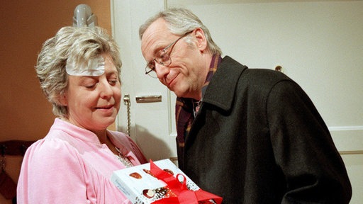 Alte Fürsorge rostet nicht: Hans (Joachim Hermann Luger) macht einen Krankenbesuch bei Helga (Marie-Luise-Marjan), die noch immer an den Folgen des Überfalls leidet.