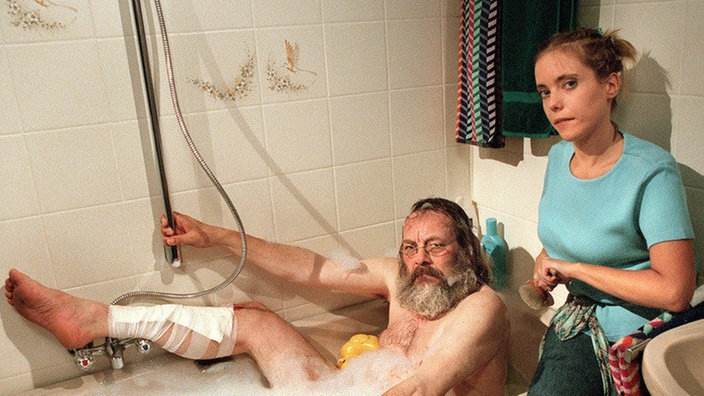 Badewannen-Wonnen: Solange Harry (Harry Rowohlt) ein krankes Bein hat, darf er in der Wohnung Zenker bleiben. Valerie (Nadine Spruß) kümmert sich um ihn.