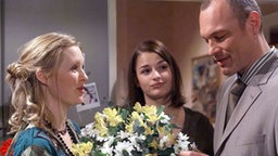 Christian überreicht Tanja einen Blumenstrauß