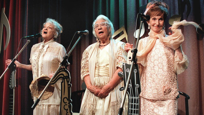 Die drei von der Gesangstelle: Hilde (Giselle Vesco, links), Frau Birkhahn (Hanna Burgwitz, Mitte) und Rosi (Margret van Munster) tragen zur musikalischen Gestaltung der Silvesterfeier bei.