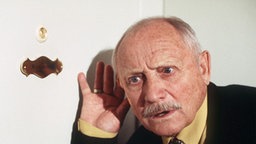 Franz hält ein Ohr an Amélies Haustür