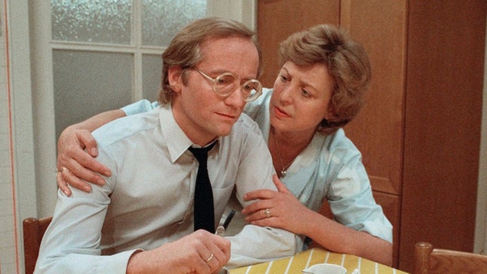 Hans Beimer (Joachim Hermann Luger) ist deprimiert. Seine Frau Helga (Marie-Luise Marjan) versucht ihn aufzumuntern.