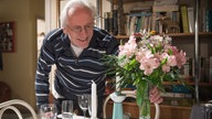 Hans deckt den Tisch mit Blumen