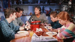 Jo sitzt mit seiner Familie am Esstisch