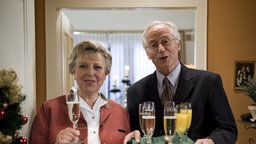 Helga und Hans prosten den Zuschauern mit Sekt zu.