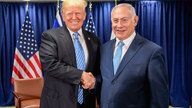 Das Bild zeigt Trump und Netanjahu wie sie Hände schütteln und in die Kamera gucken.