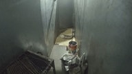 Blick auf einen Metallschacht, wo Asylsuchende angekettet und festgehalten werden.