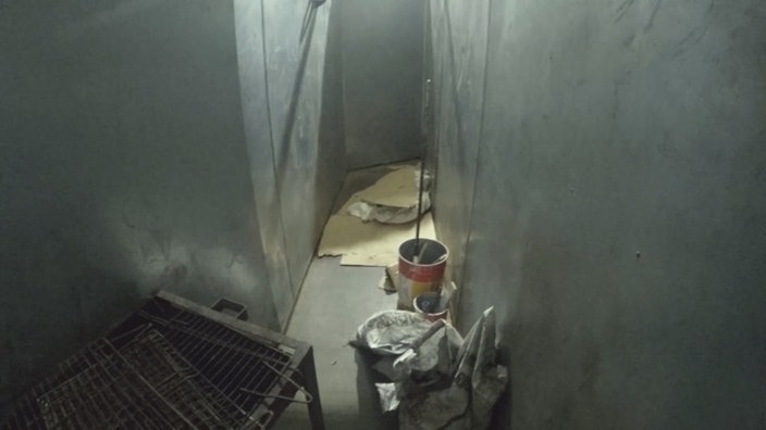 Blick auf einen Metallschacht, wo Asylsuchende angekettet und festgehalten werden.