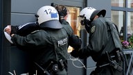 Ausschreitungen bei Hooligan-Demo - Polizei setzt Wasserwerfer ein