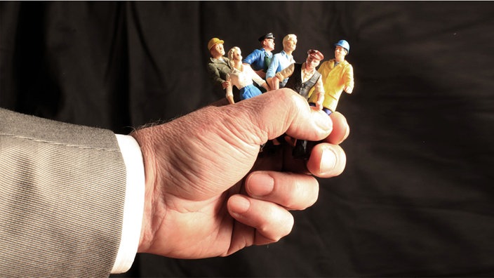 Symbolfoto Hand mit Speilfiguren