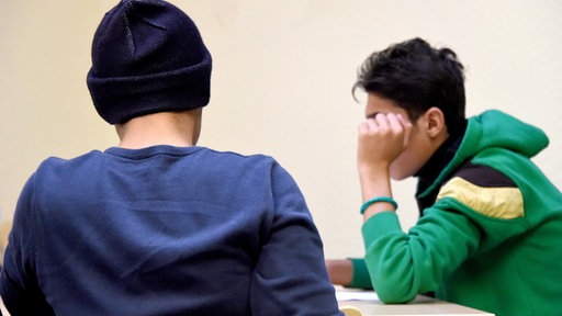 Zwei Jugendliche sitzen an einem Tisch
