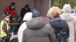 Menschen stehen in Dortmund an der Essensausgabe an.