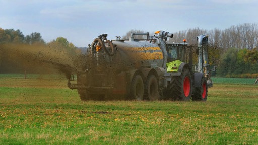 Gülle wird von einem Landwirt auf einem Feld ausgebracht.