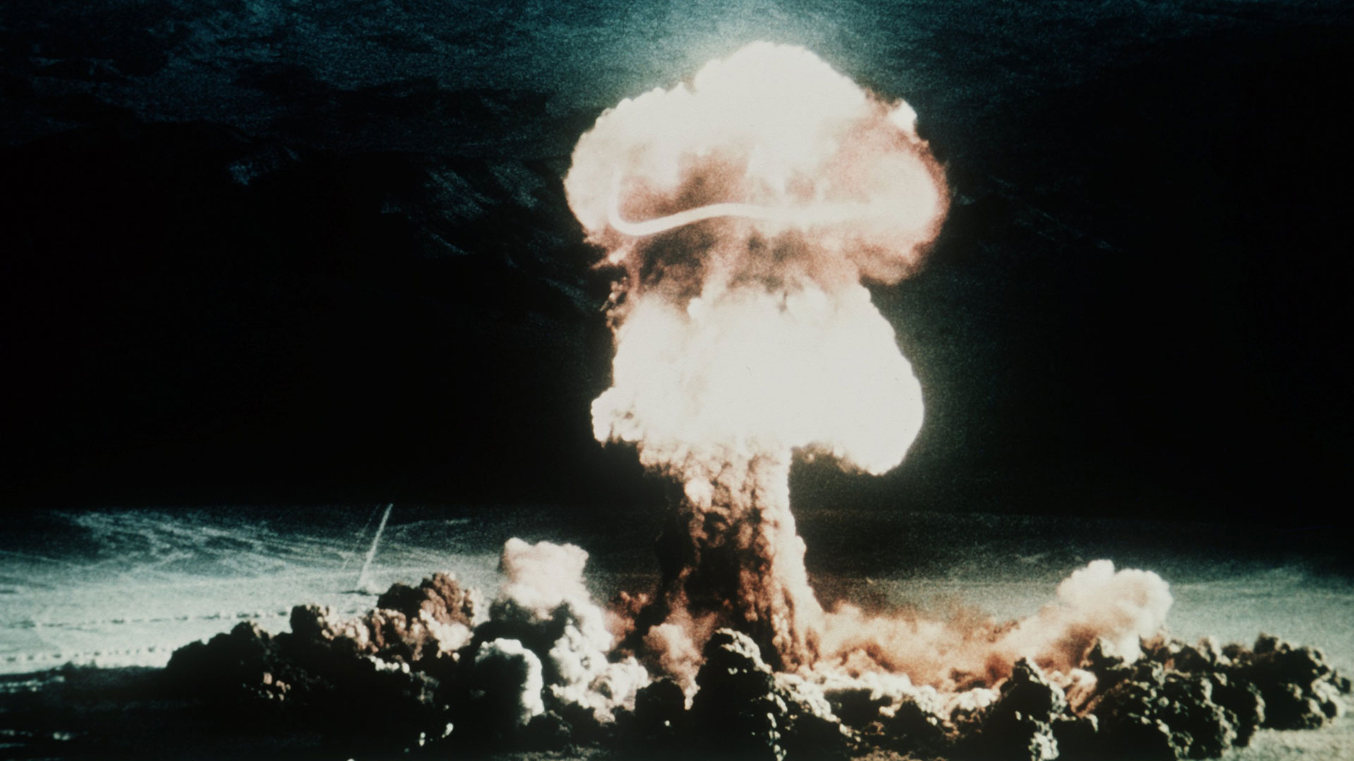 Ein Atompilz steigt nach der Explosion einer Atombombe über dem Testgelände in der Wüste von Nevada auf
