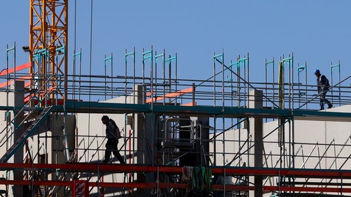 Symbolfoto: Handwerker auf einem Gerüst auf einer Baustelle