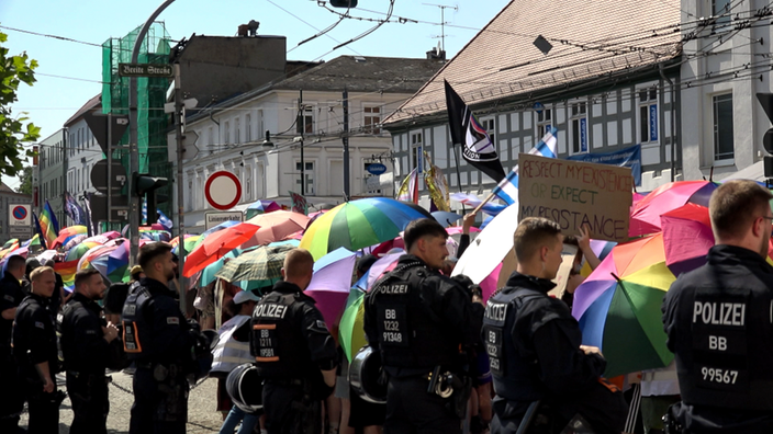 Polizisten stehen neben einem CSD-Umzug