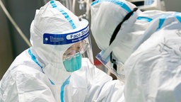 Ärzte in Schutzanzügen behandeln im Krankenhaus "Zhongnan" der Universität Wuhan einen Patienten.