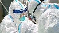 Ärzte in Schutzanzügen behandeln im Krankenhaus "Zhongnan" der Universität Wuhan einen Patienten.