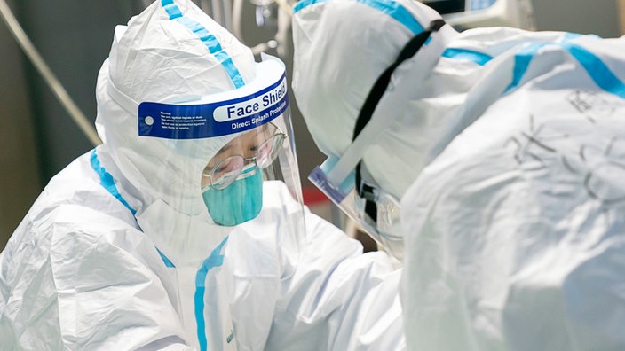 Ärzte in Schutzanzügen behandeln im Krankenhaus "Zhongnan" der Universität Wuhan einen Patienten.