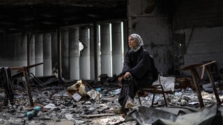 Die getötete palästinensische Fotografin Fatma Hossana sitzt, umgeben von Trümmern, in einem Haus in Gaza.
