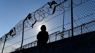 Ein Migrant sitzt neben einem Zaun des Flüchtlingslagers Moria.