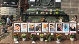 Unter dem Brüder Grimm-Denkmal auf dem Hanauer Marktplatz wird an die Opfer des Anschlags vom 19. Februar erinnert.