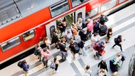 Menschen steigen in eine Regionalbahn ein - Blick aus der Vogelperspektive. 