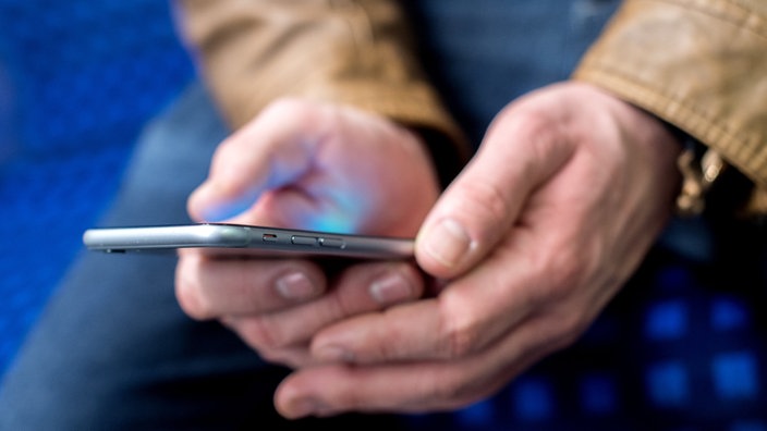 Mann hält ein Smartphone in seinen Händen