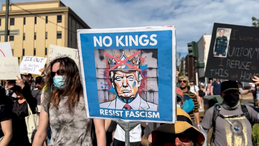 Bei einem Protest gegen Trump wird ein Plakat mit der Aufschrift "NO KINGS" hochgehalten.