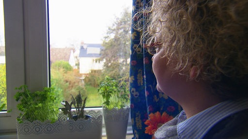 Eine Frau schaut durch ein Fenster