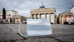 Eine medizinische Maske vor dem Brandenburger Tor