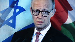Bundeskanzler Friedrich Merz vor der israelischen und palästinensische Flagge