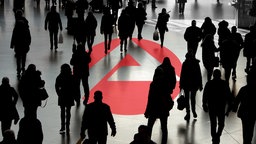 Das Logo der Agentur für Arbeit inmitten einer anonymen Menschenmenge