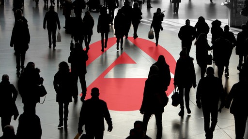 Das Logo der Agentur für Arbeit inmitten einer anonymen Menschenmenge